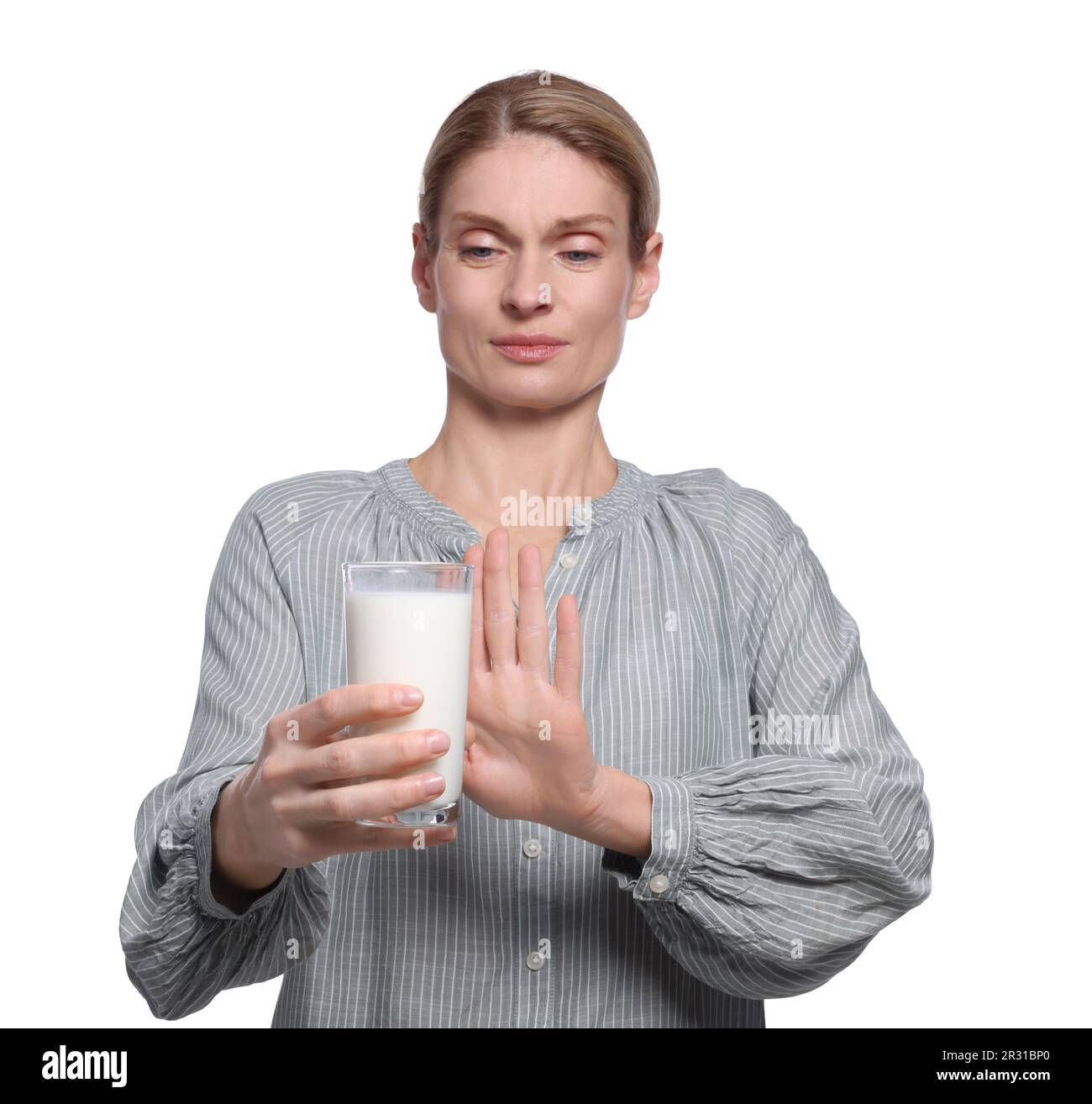 Woman with glass of milk suffering from lactose intolerance on white