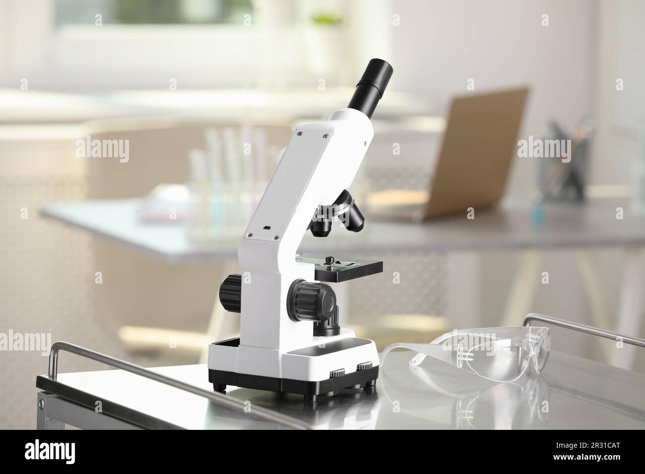 Modern medical microscope on metal table in laboratory Stock Photo - Alamy