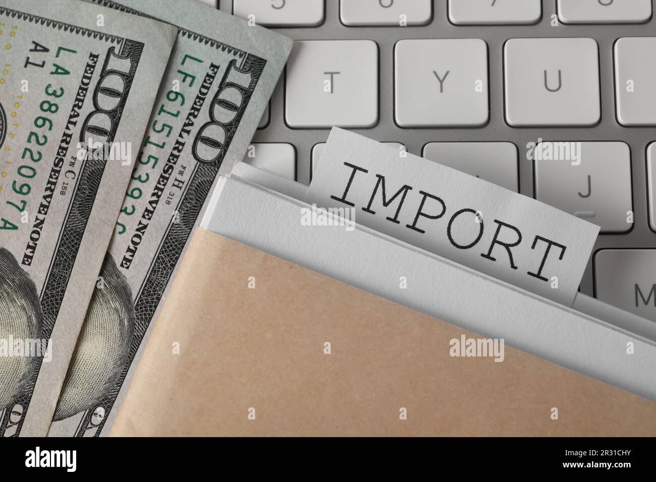 Note with word Import in documentation and dollar banknotes on computer keyboard, top view Stock Photo