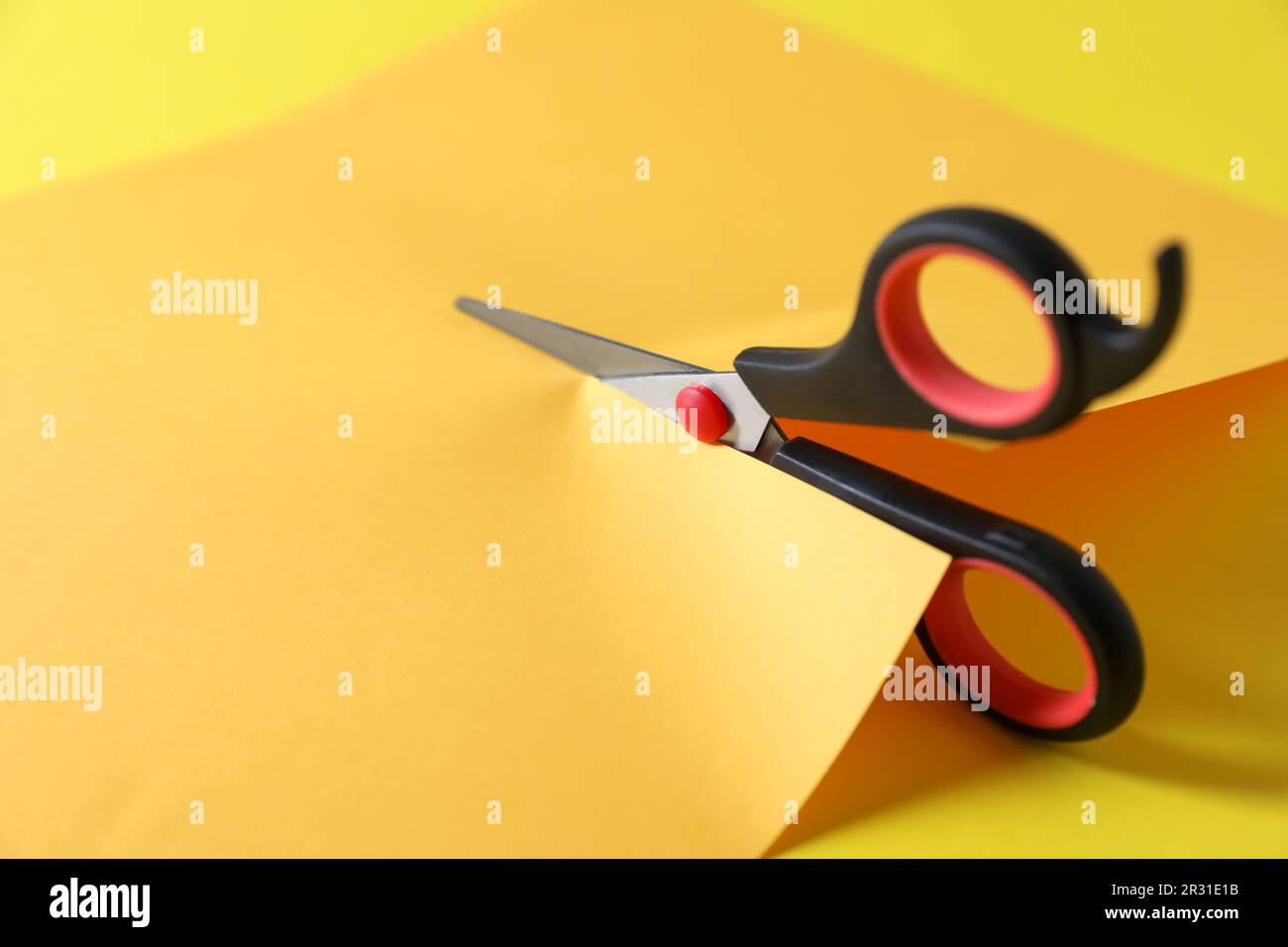 Woman cutting wrapping paper with scissors on desk stock photo