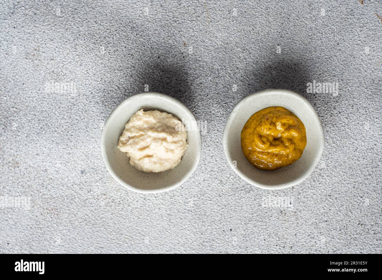 Overhead view of two bowls of homemade mustard and horseradish sauce Stock Photo