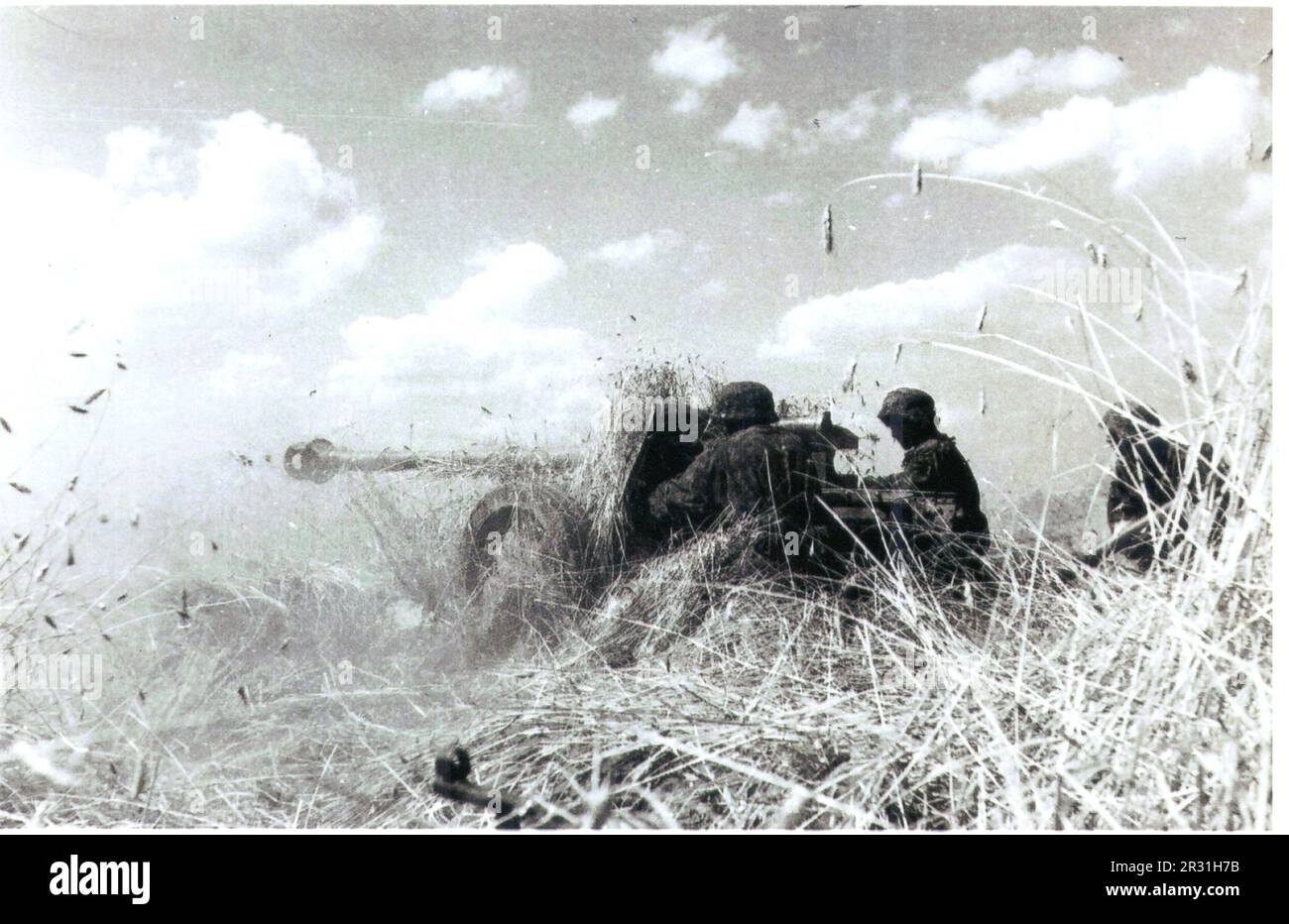 World War Two B&W photo German an Anti-Tank Gun fires on the Eastern Front during the Summer of 1944. The Gunners in Camo Smocks are from the 5th SS Panzer Division Wiking during a heavy defensive battle in Poland Stock Photo