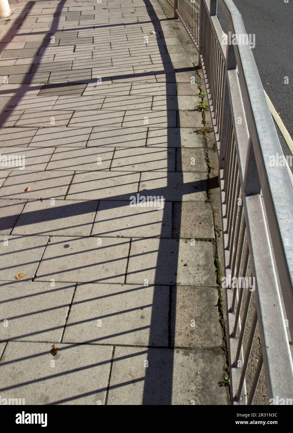 Pavment Railing railings and shadows on the pavement Stock Photo - Alamy