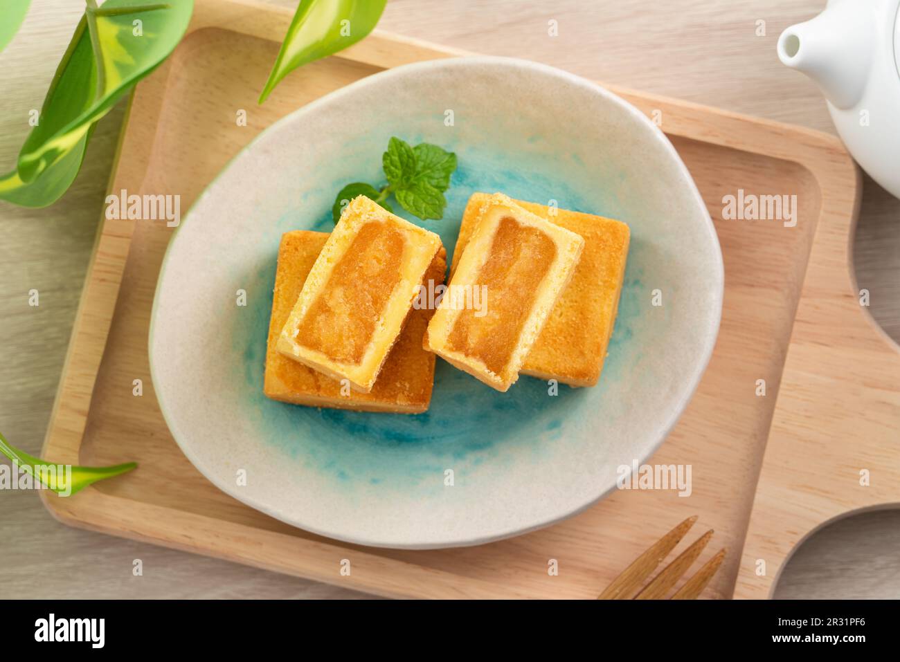 Delicious Taiwanese famous pineapple cake pastry dessert in a plate on wooden table background with hot tea. Stock Photo