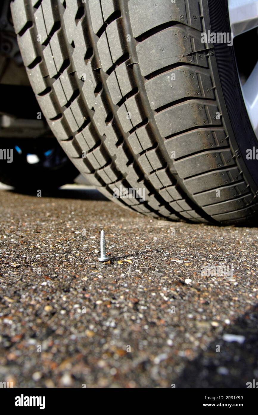 Screw in front of a tire Screw and tire Stock Photo Alamy
