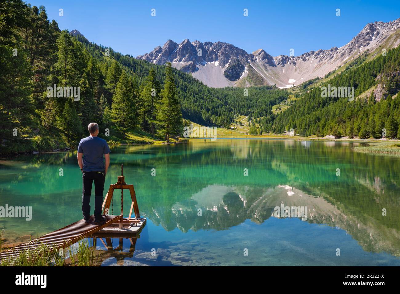 Man at lakeside of Orceyrette Lake in Summer in Briancon Region. Hautes-Alpes (05), French Alps, France Stock Photo
