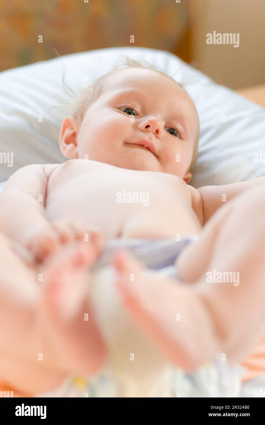 kleines süßes baby beobachtet seine füße Stock Photo