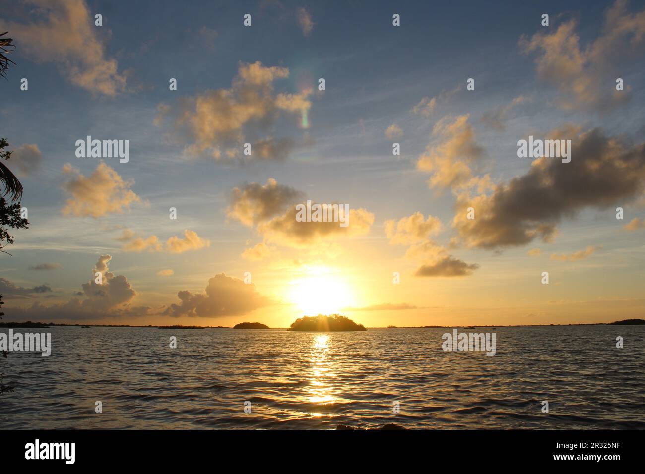 sunrise over the Caribbean sea and an island with dark blue water and ...