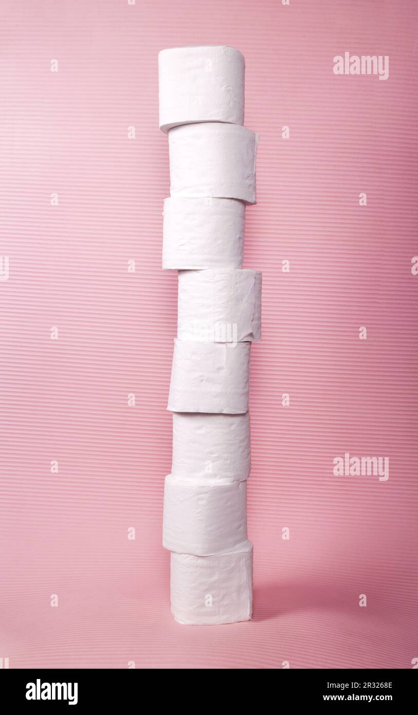 Tall toilet paper tower made of 8 stacked white tissue rolls isolated