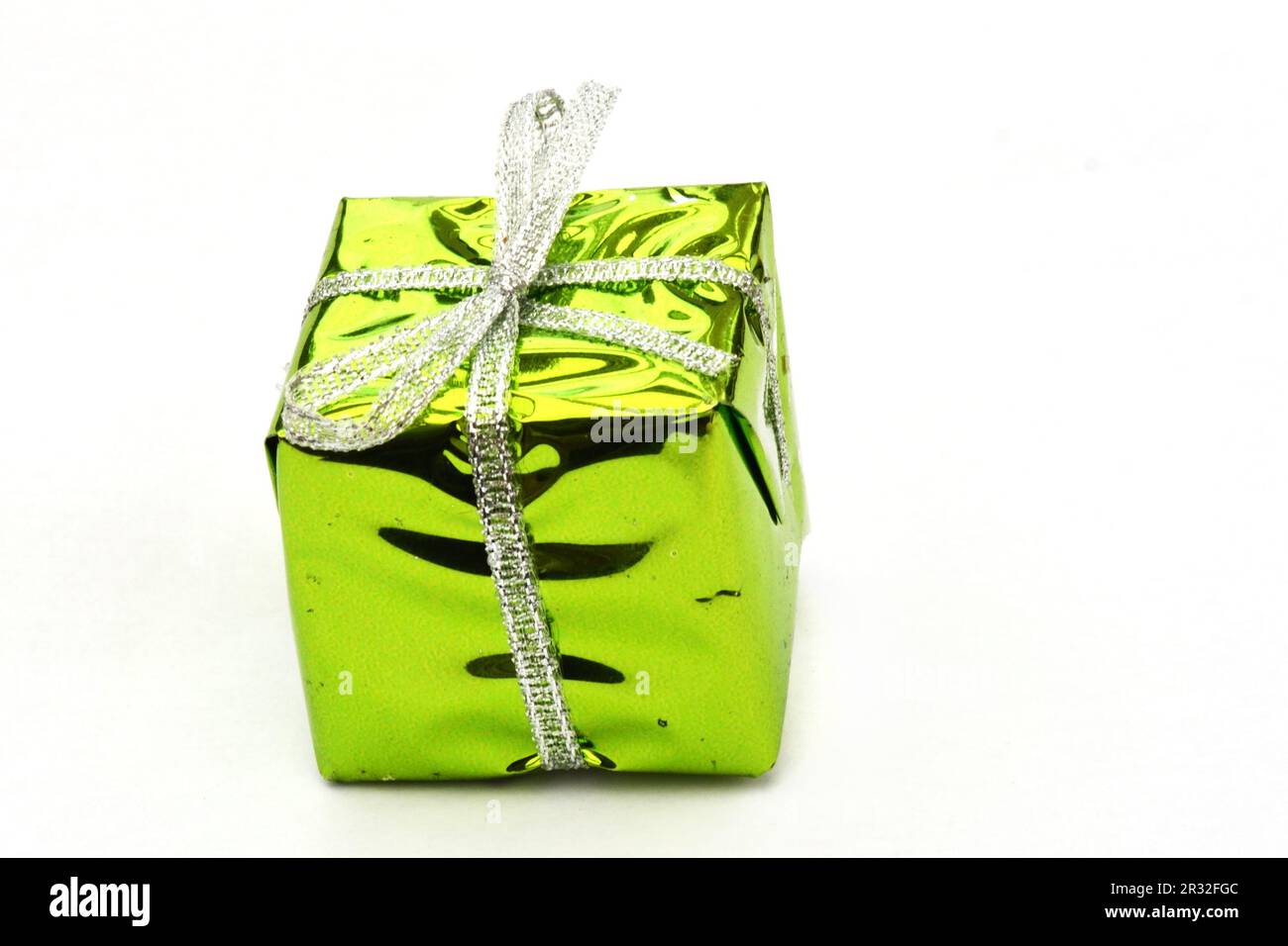 Stylish christmas gift wrapped in gold paper and green ribbon, festive  decorations on green Stock Photo by Sonyachny