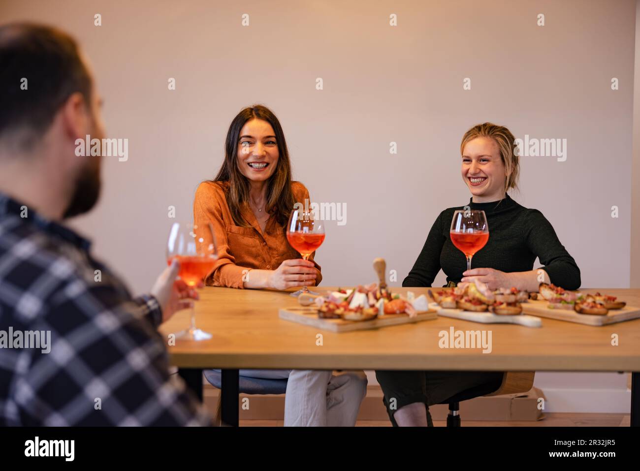 Young group of people enjoying a meal at home. Stock Photo