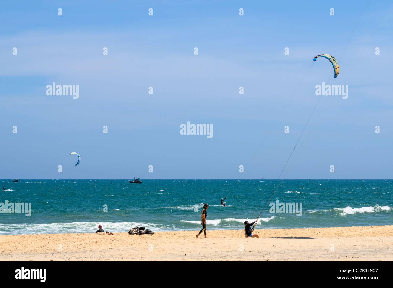 Kitesurfers in action on and off the fine, sandy beach in Mui Ne, Vietnam. Stock Photo