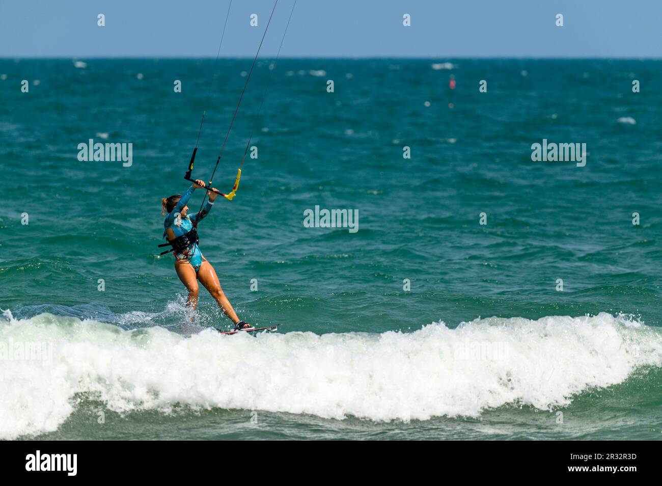 A female kitesurfer rides the waves off the beach in Mui Ne, Vietnam ...
