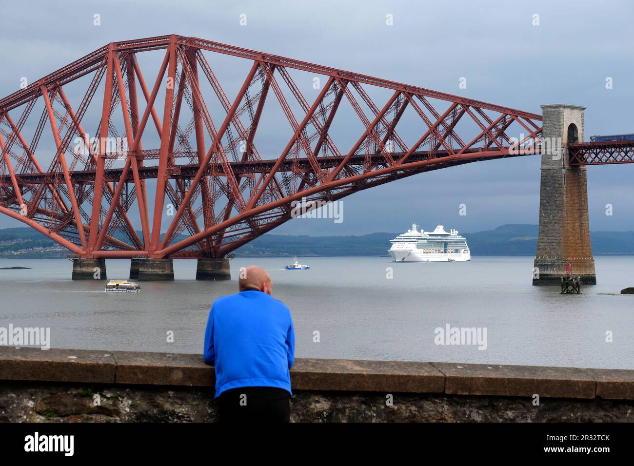 South Queensferry, Scotland, UK. 22nd May 2023. Jewel of the Seas, a 90,000 tonne, 965 feet, mega cruise liner with 12 passenger decks and equiped with its own waterpark, theatre, casino, elevators and rock climbing wall, arrived in the Forth estuary this morning for a rare stopover. Berthed beside the Forth bridge allowing the sense of scale to be appreciated. Credit: Craig Brown/Alamy Live News Stock Photo