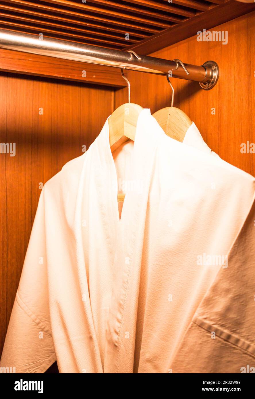 Bathrobes with wooden hangers in hotel wardrobe Stock Photo Alamy