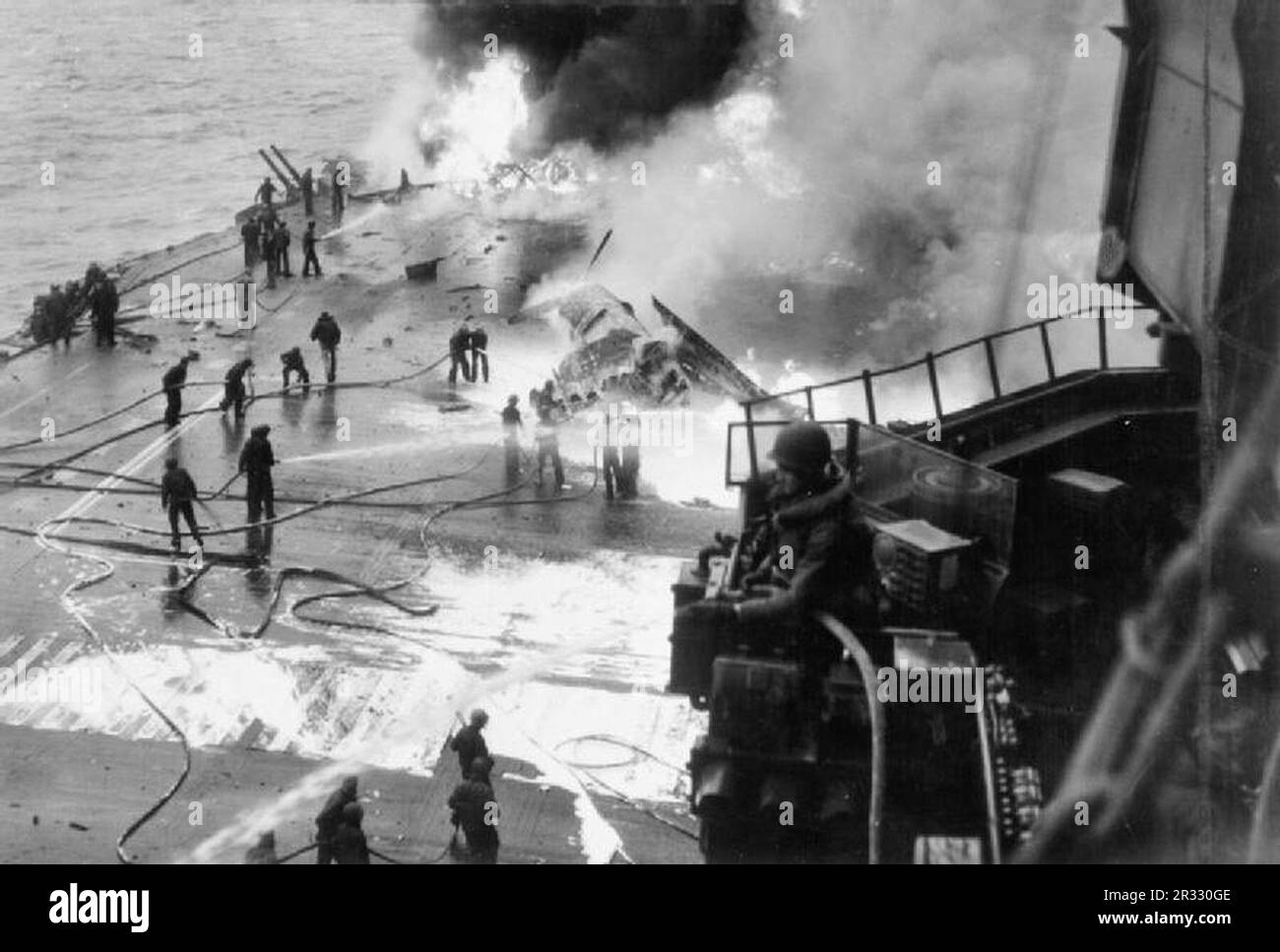 The U.S. Navy aircraft carrier USS Saratoga (CV-3) burning after five 'Kamikaze' suicide planes hit the forward flight deck off Chi-chi Jima, shortly after 17:00h, 21 February 1945. Another attack at 19:00h scored an additional bomb hit. 123 of her crew were dead or missing as a result of the attacks. Stock Photo