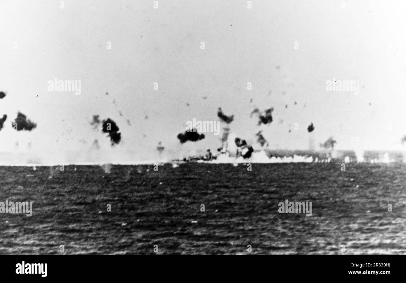 The U.S. Navy destroyer USS Zellars (DD-777) after a kamikaze crashed into her port side on 12 April 1945. The plane hit Zellars forward of the bridge in her number 2 handling room. The 500-kilogram bomb tore through several light bulkheads before exploding on the starboard side of the ship in the scullery. Zellars temporarily lost all power, and the fireroom had to be secured. She had to return to the United States for repairs. Stock Photo