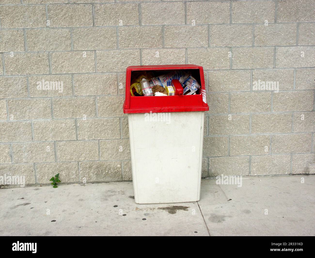 Trash can outside a business is full of trash. Stock Photo