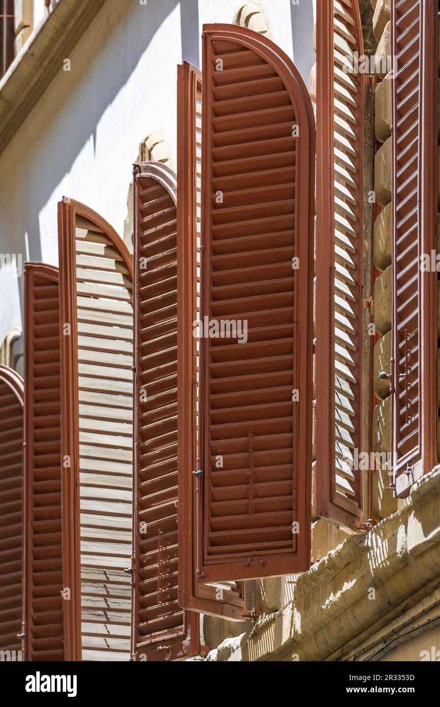 Arched wooden shutters on a Renaissance gothic building near the Santa Croce Basilica church in Centro Storico or Historic Centre of Florence, Italy Stock Photo