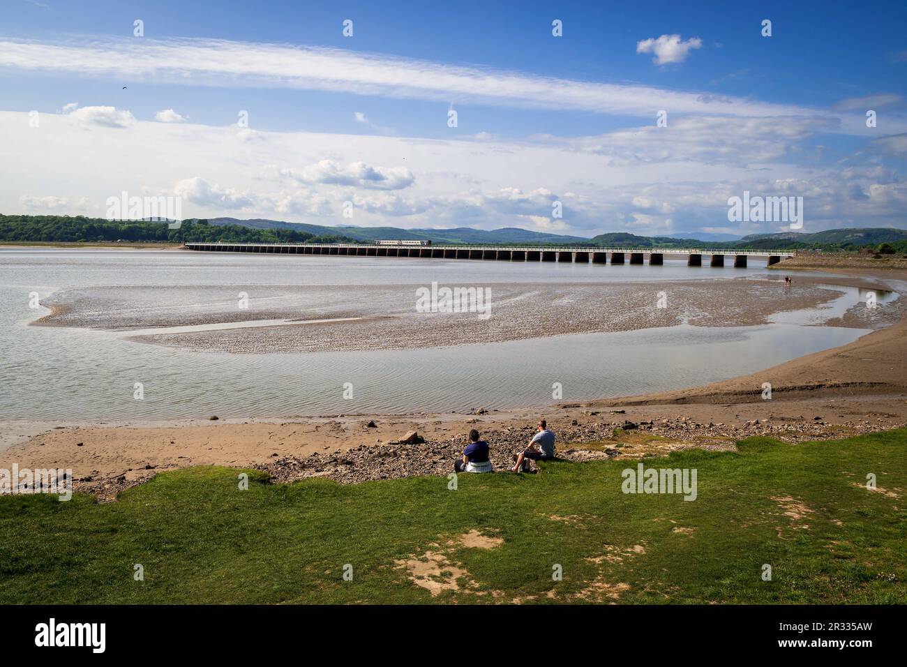 The river Kent estuary with a train passing over the Arnside viaduct. Stock Photo