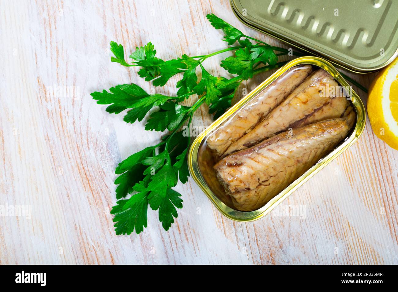 Tasty fillet of mackerel in sunflower oil with greens and lemon Stock Photo