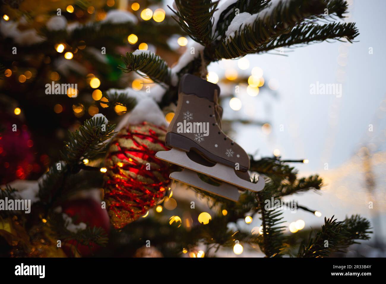 beautiful multi-colored toys on a Christmas tree against the background of lights and snow Stock Photo