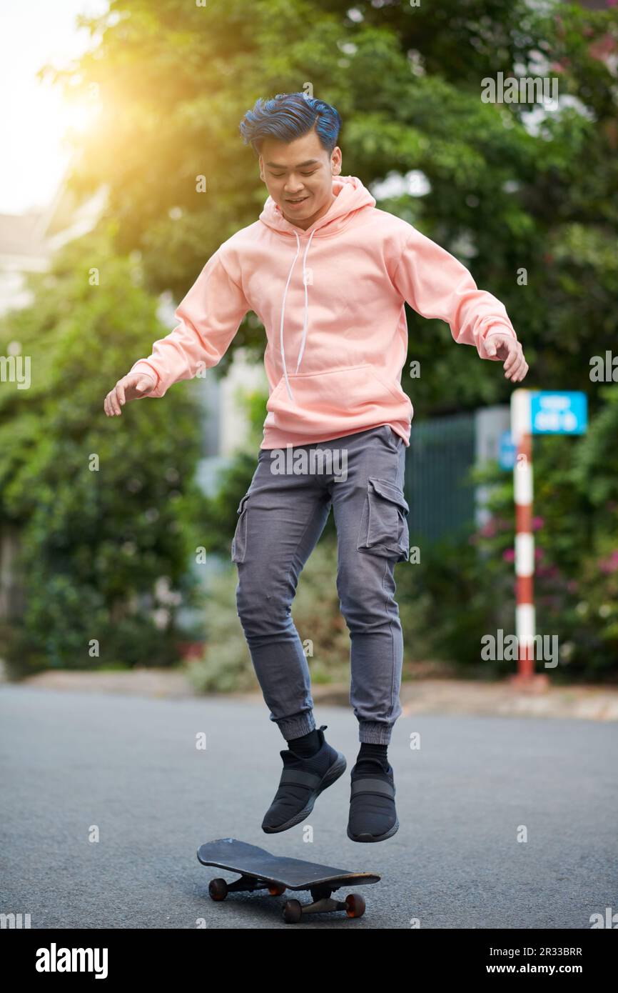 Young man performing stunt on skateboard Stock Photo