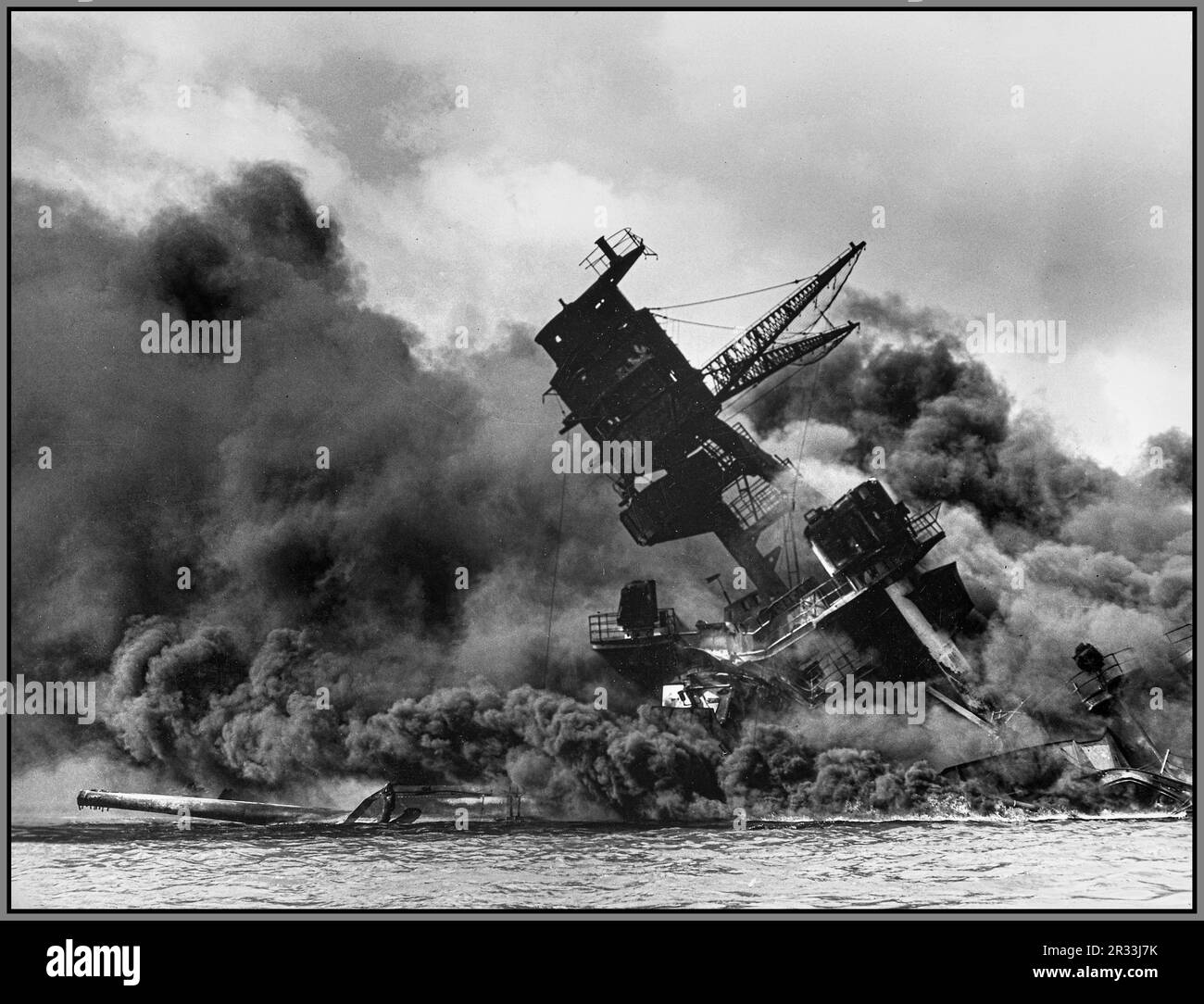 The USS Arizona (BB-39) burning after the Japanese attack on Pearl Harbor, 7 December 1941. USS Arizona sunk at Pearl Harbor. The ship is resting on the harbor bottom. The supporting structure of the forward tripod mast has collapsed after the forward magazine exploded. WW2 World War II Second World War Stock Photo