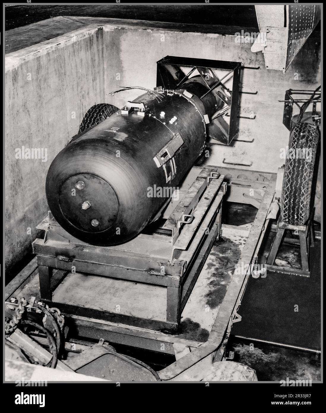 ATOMIC ATOM  NUCLEAR BOMB HIROSHIMA  WW2 A-Bomb. LB (Little Boy) unit on trailer cradle in pit on Tinian Island, before being loaded into aircraft Enola Gay's bomb bay. [Note bomb bay door in upper right-hand corner.] , 08/1945.  3.05 meter long first tactical nuclear bomb 'Little Boy' which is about to be loaded in to a B-29 plane bound for Hiroshima Japan. This bomb will later cost the lives of more than 70,000 people. Stock Photo