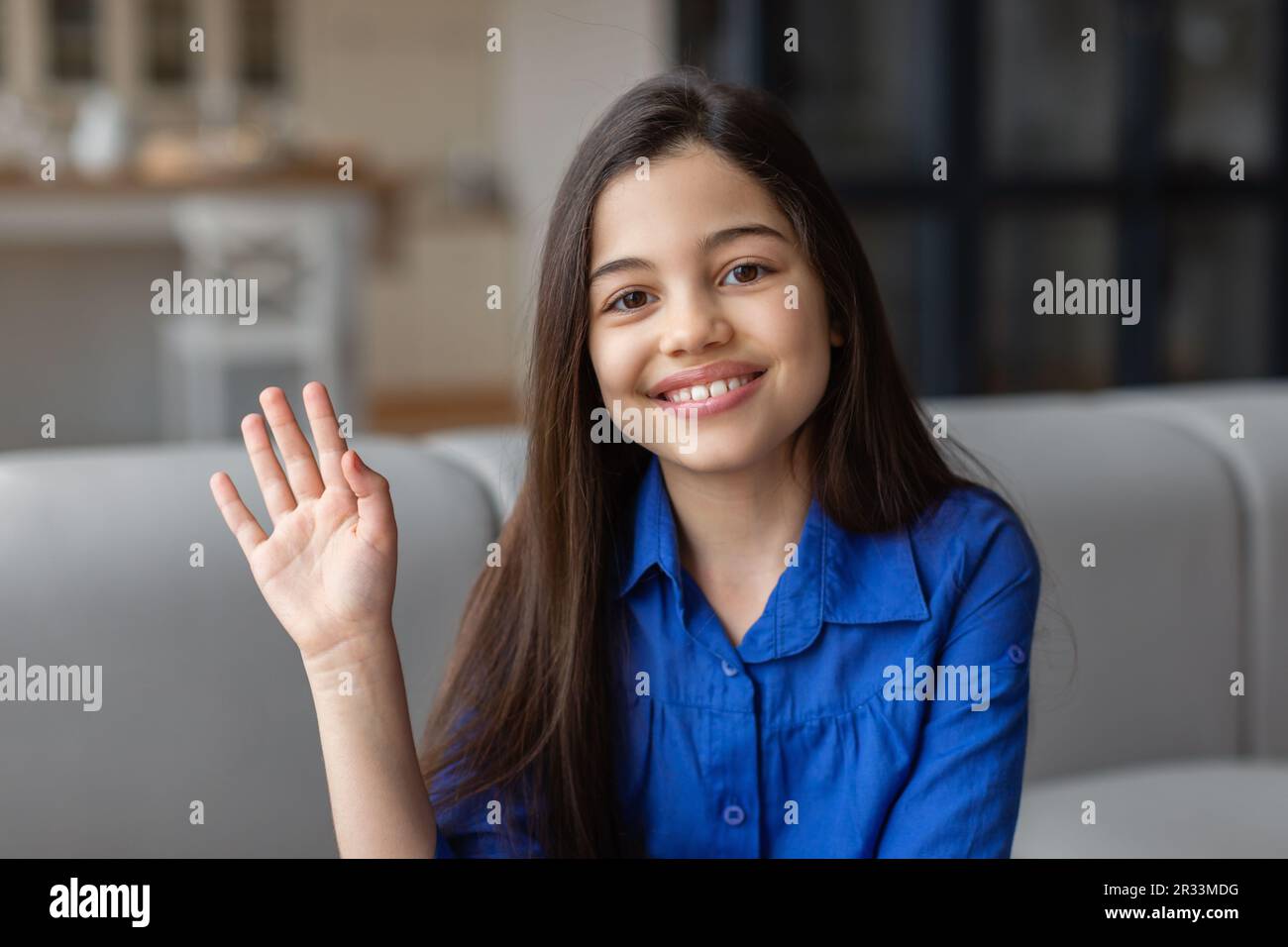 Portrait Of Cheerful Preteen Girl Gesturing Hello At Home Stock Photo ...