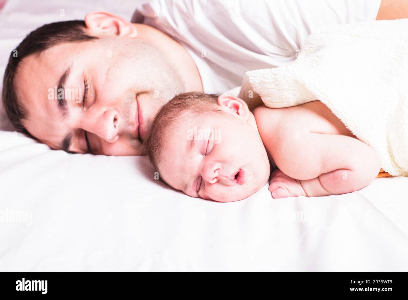 Baby sleeps with dad Stock Photo Alamy