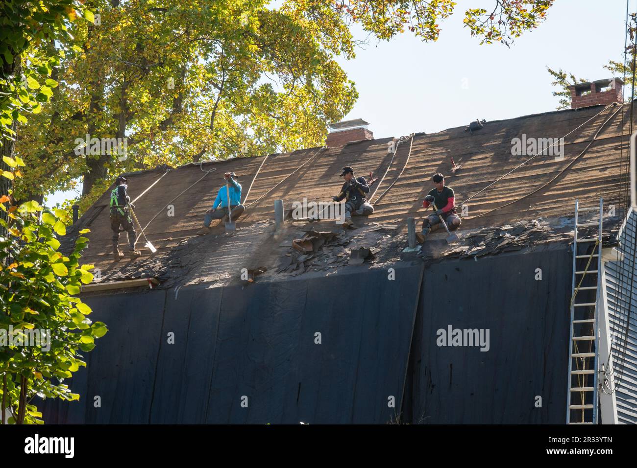 Workers removing roof from single family residence. Stock Photo