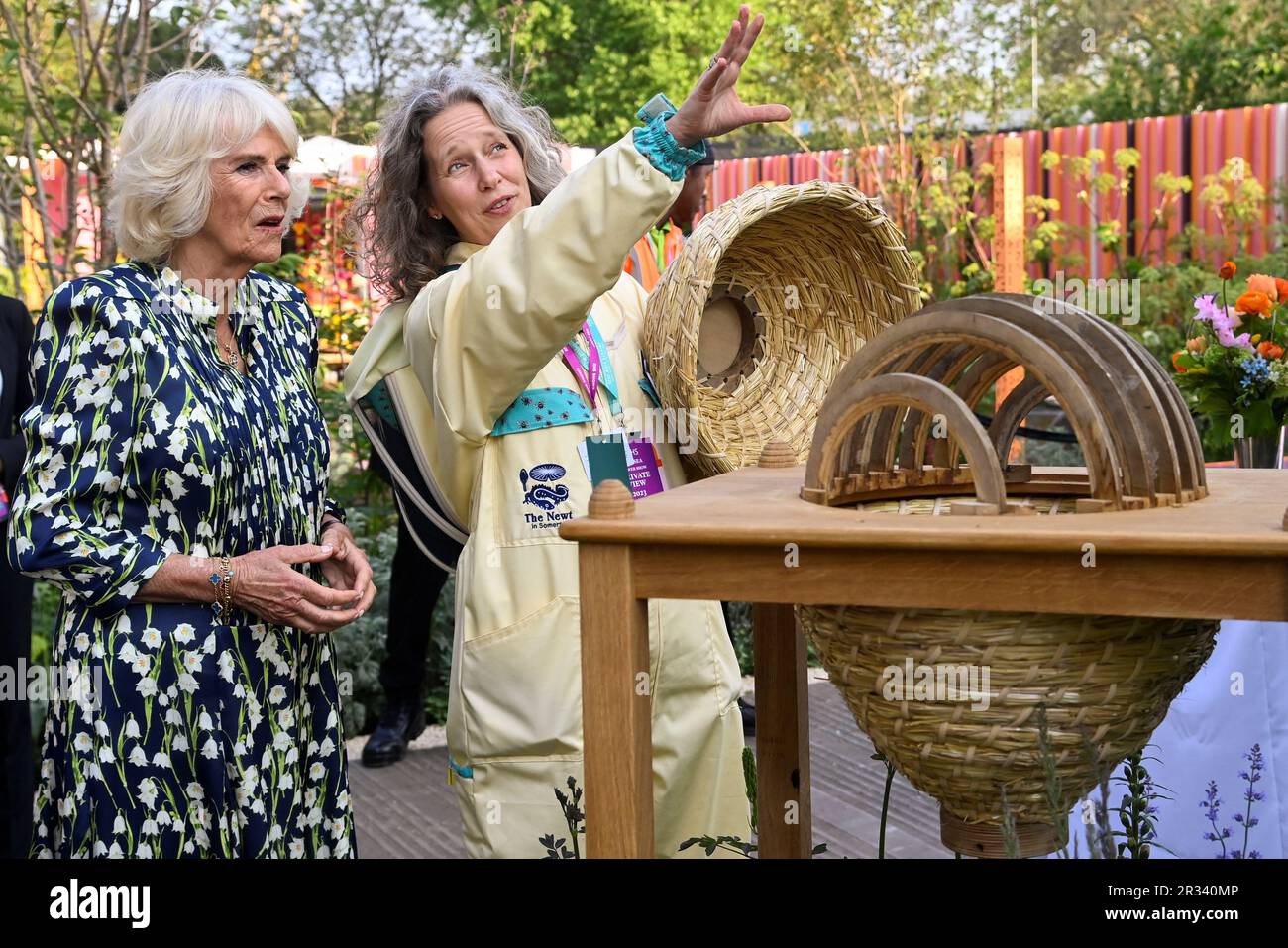 Queen Camilla views a bee house with beekeeper Paula Carnell (right) during a visit to the RHS Chelsea Flower, at the Royal Hospital Chelsea, London. Picture date: Monday May 22, 2023. Stock Photo