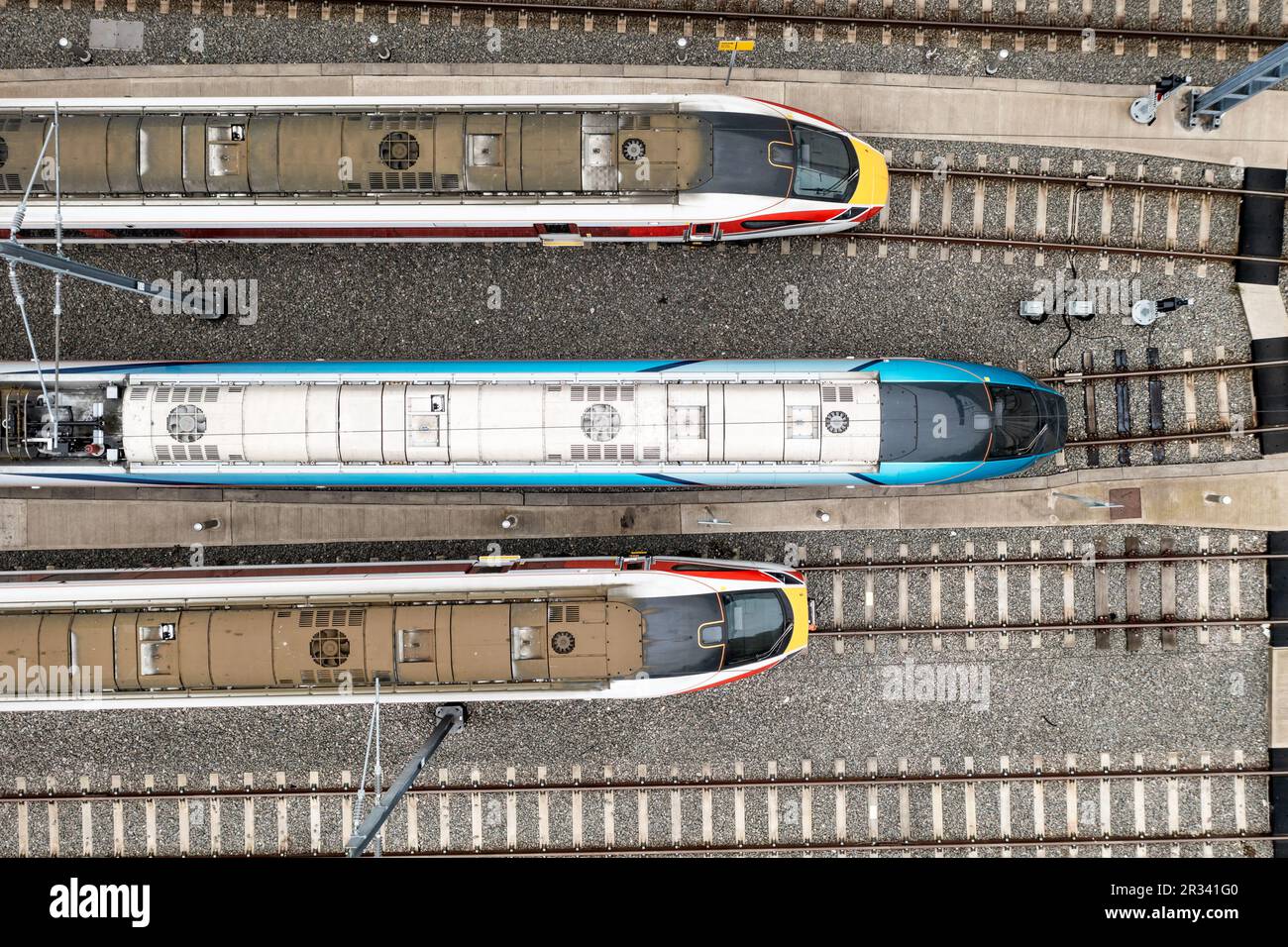 Aerial view directly above high speed passenger trains heading towards a railway junction in a rail accident concept image Stock Photo