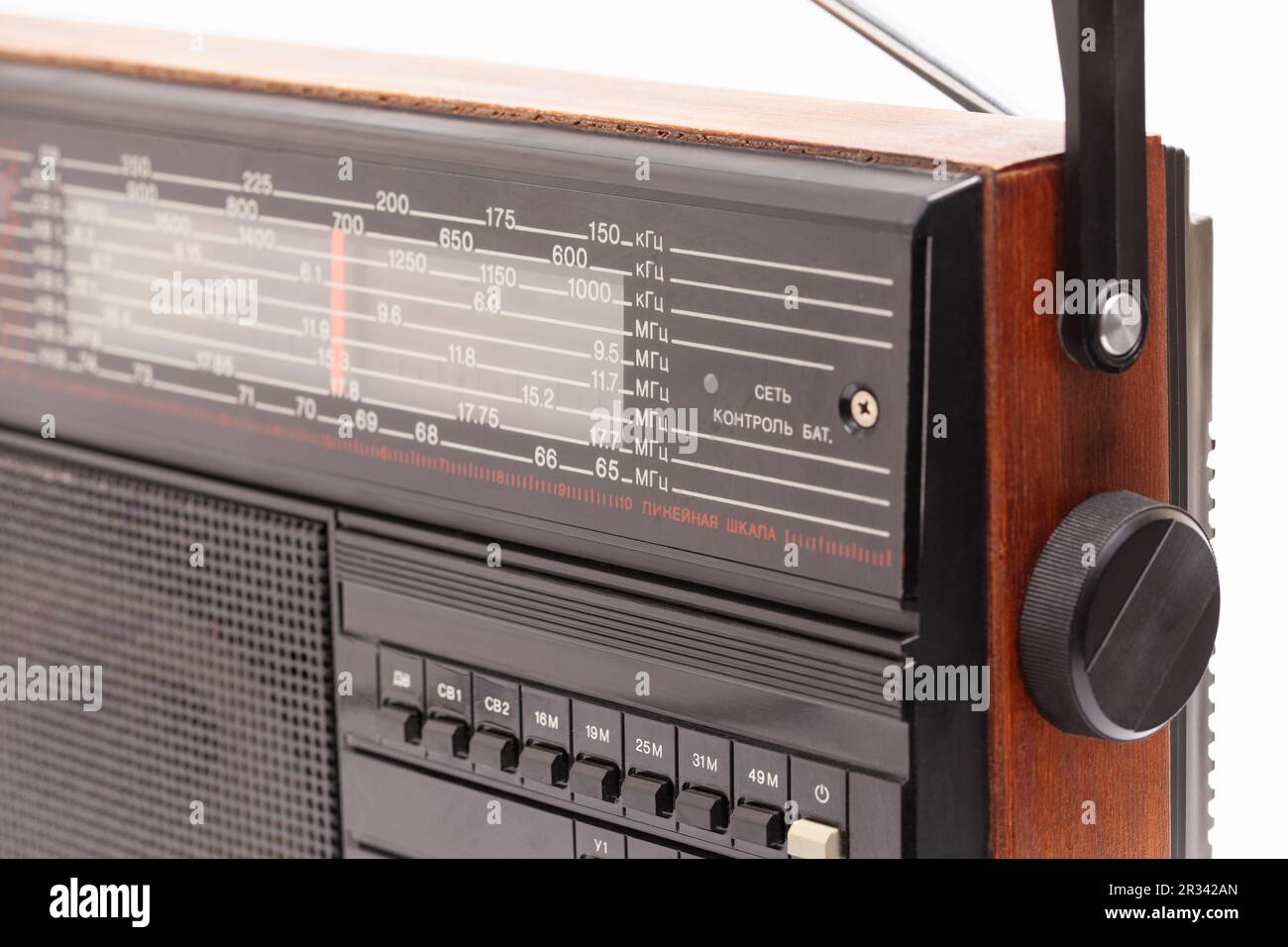 Old transistor radio isolated on white English translation network, battery monitoring, linear