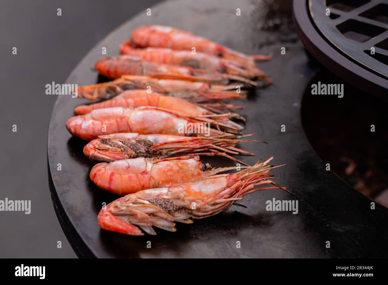 Process of cooking fresh red langoustine shrimps, prawns on grill
