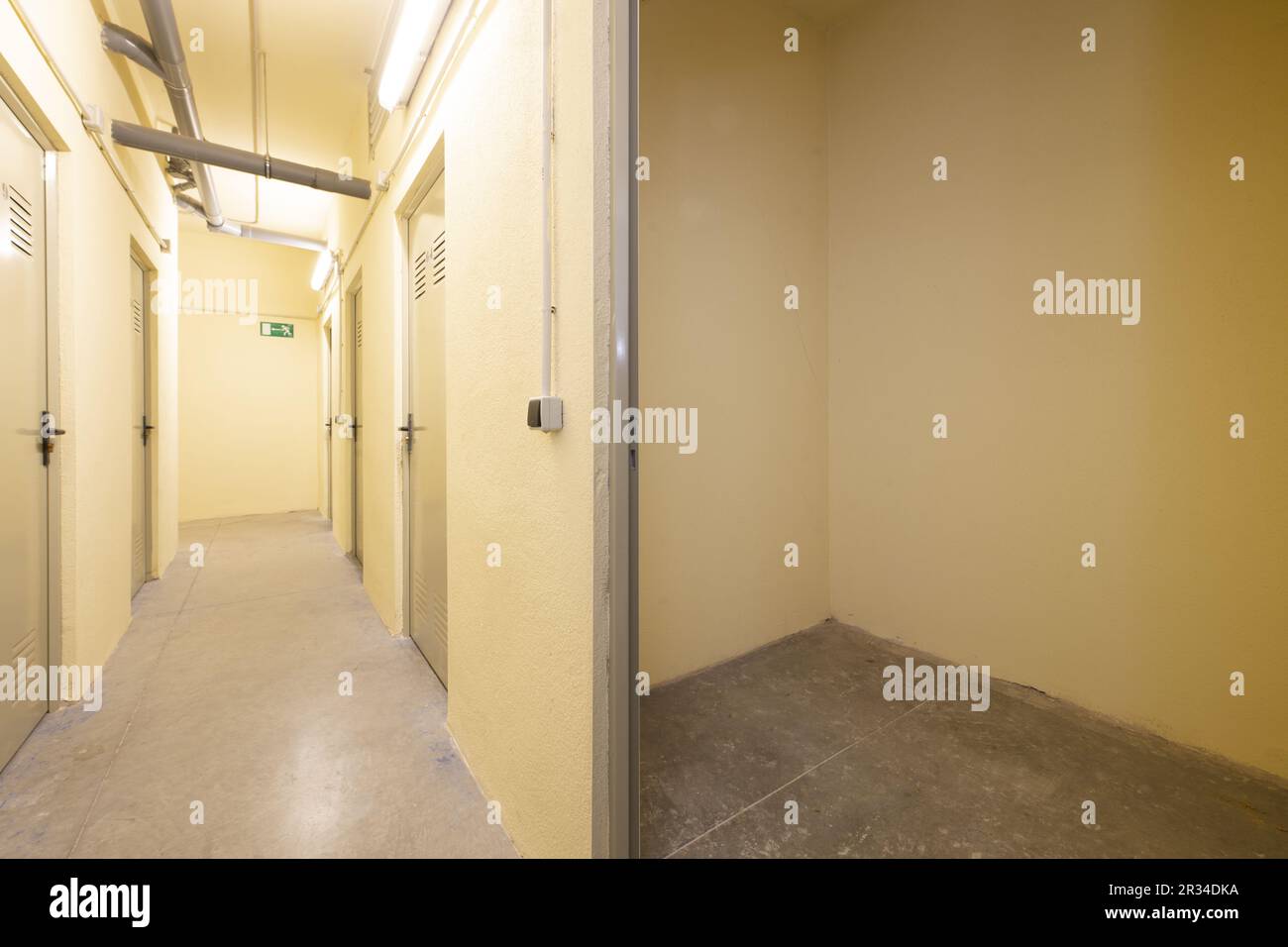 An empty storage room on the ground floor of a residential apartment building with cream-yellow painted walls Stock Photo