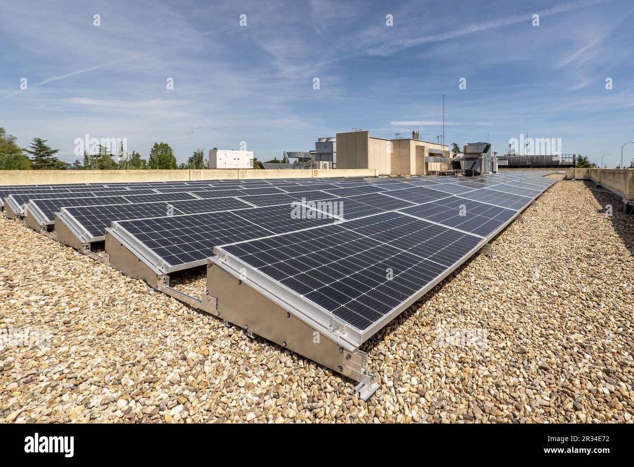 Rooftop of an office building covered in gravel with a bunch of solar panels on top Stock Photo