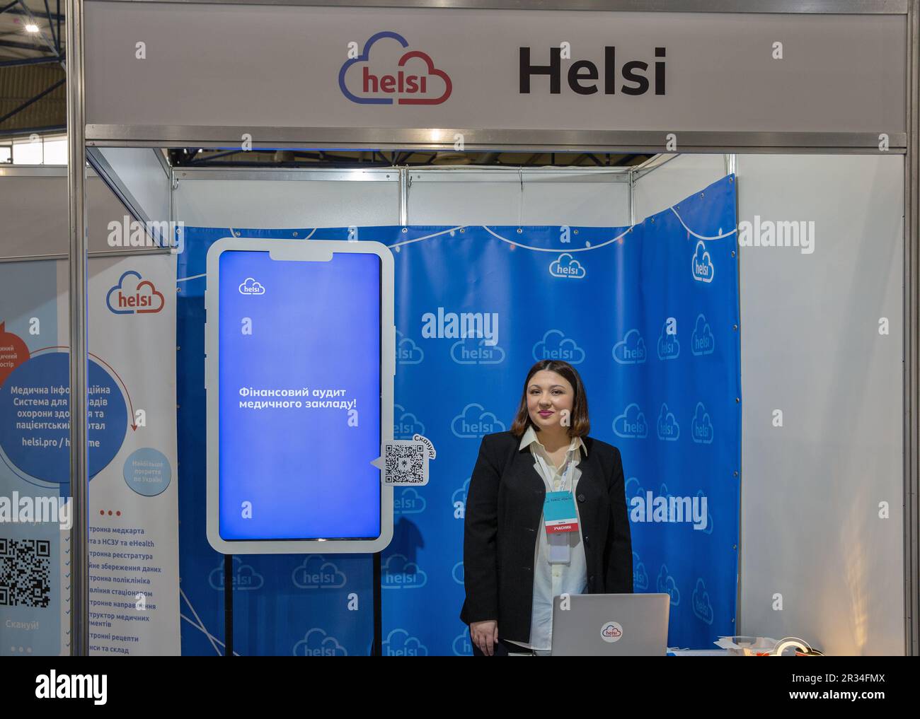 Kyiv, Ukraine - March 29, 2023: Presenter works on Helsi booth at exhibition in MVC. It is a modern Ukrainian electronic medical system for patients, Stock Photo