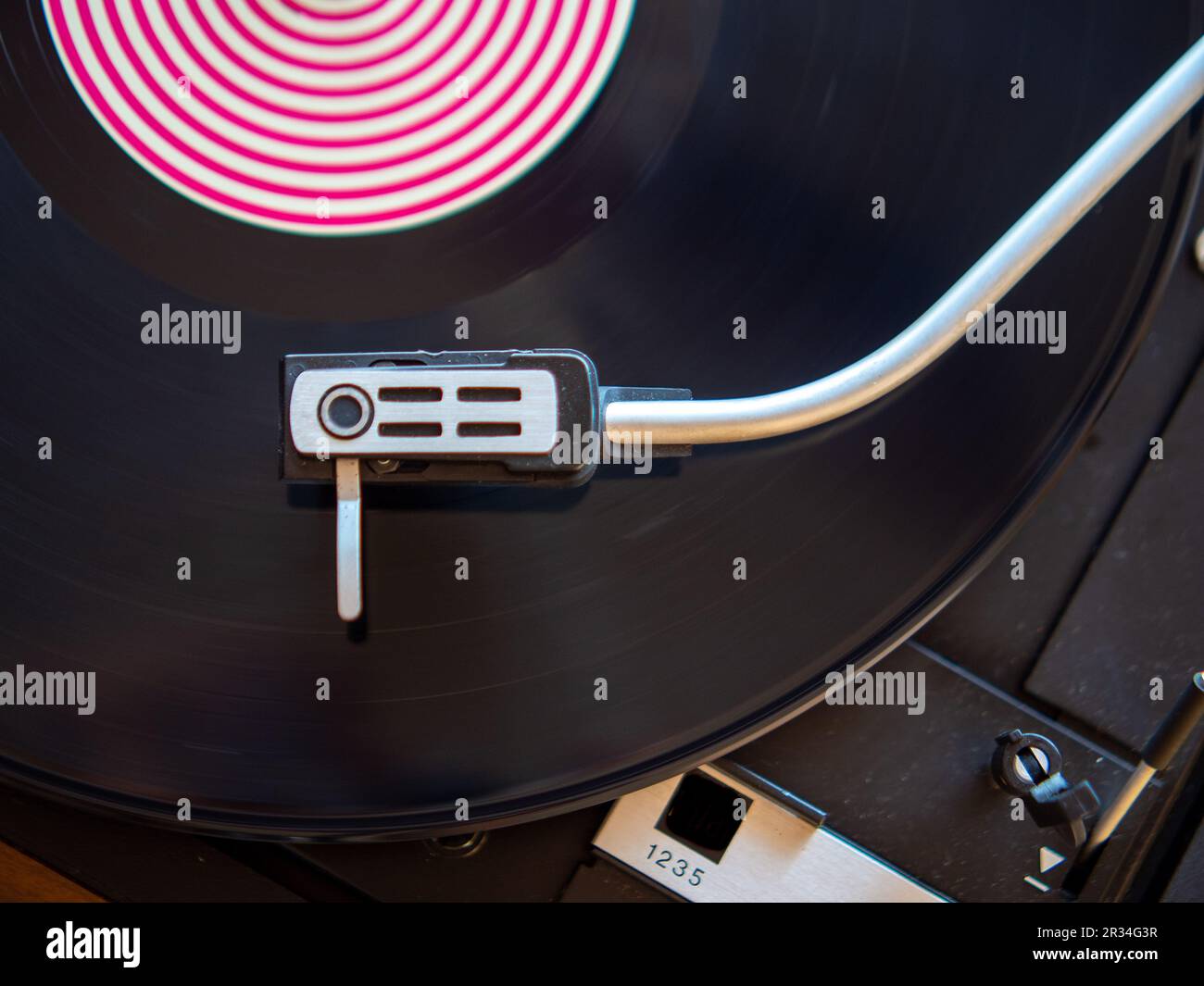 Detail of a needle on a track of a black vinyl record. Vintage