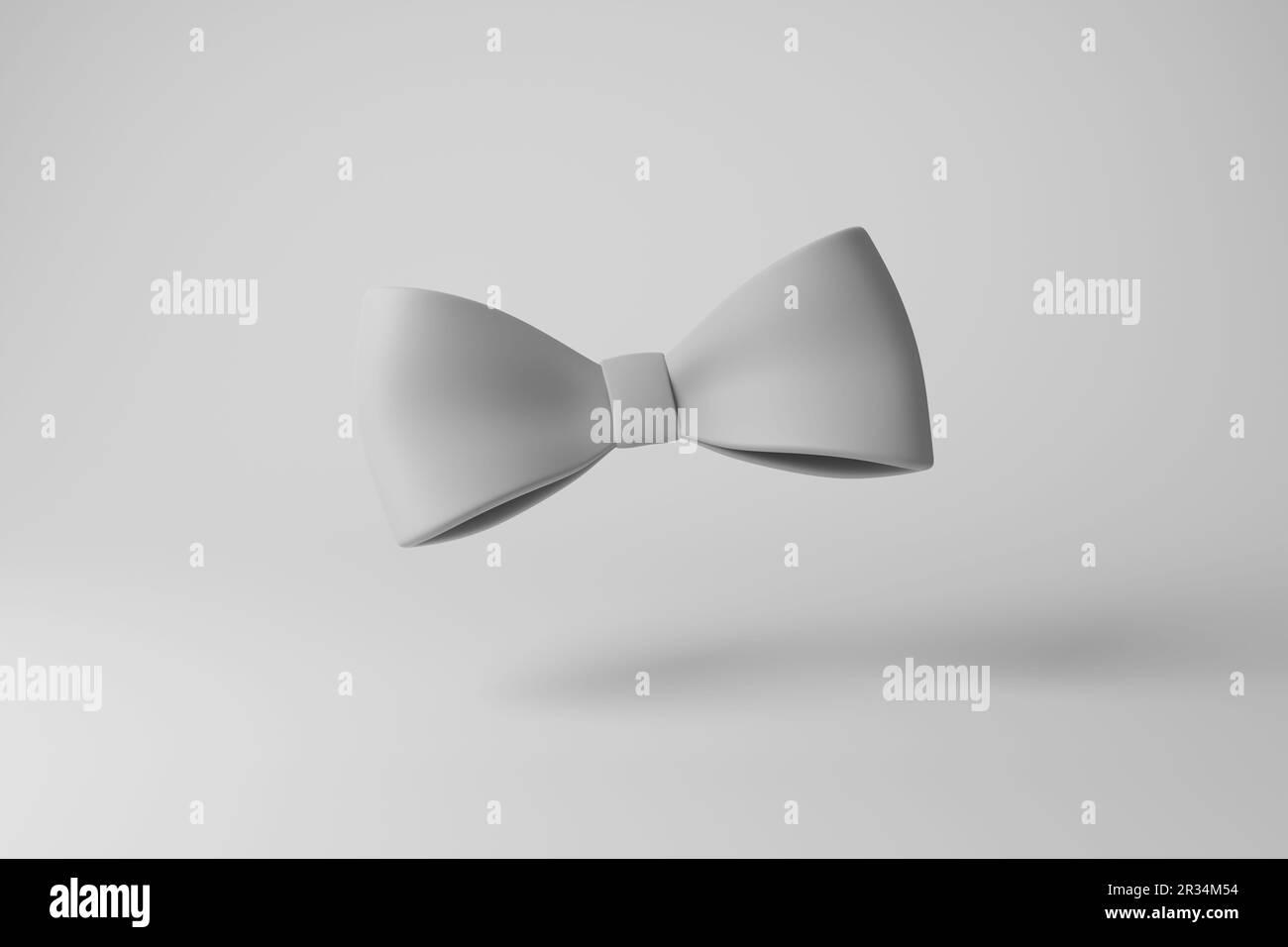 White bowtie casting shadow on white background creating greyscale monochrome. The concept of minimalism, dress code, formal events  and courtesy Stock Photo