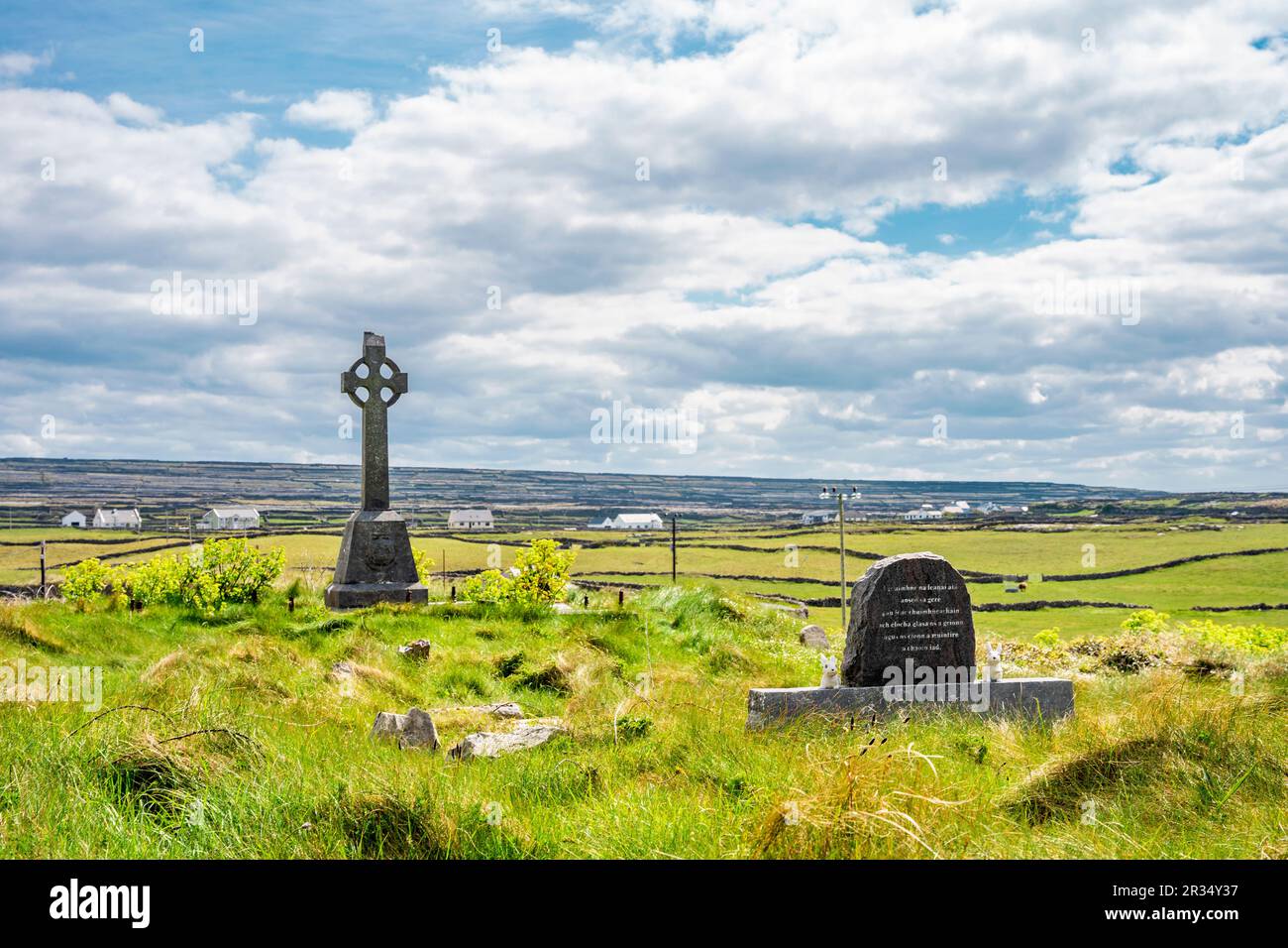 Graveyard with celtic cross in Inis Mór, or Inishmore, the largest of the Aran Islands in Galway Bay, off the west coast of Ireland. Stock Photo