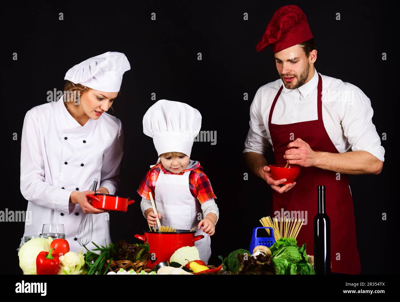 Happy family preparing breakfast together. Homemade food. Parents teaching little boy to cook