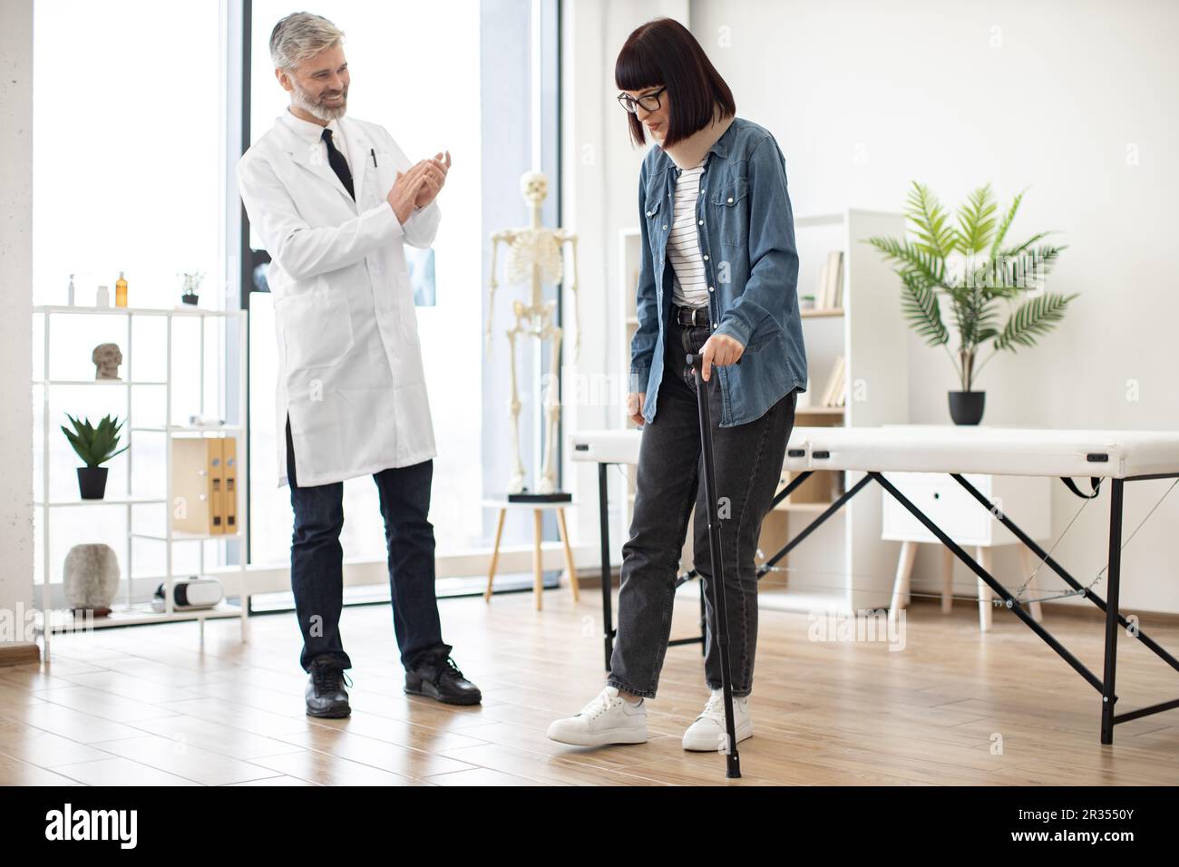 Cheerful doctor in white coat clapping hands while lady in C