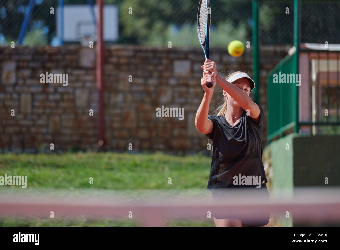 A young girl showing professional tennis skills in a competitive match ...