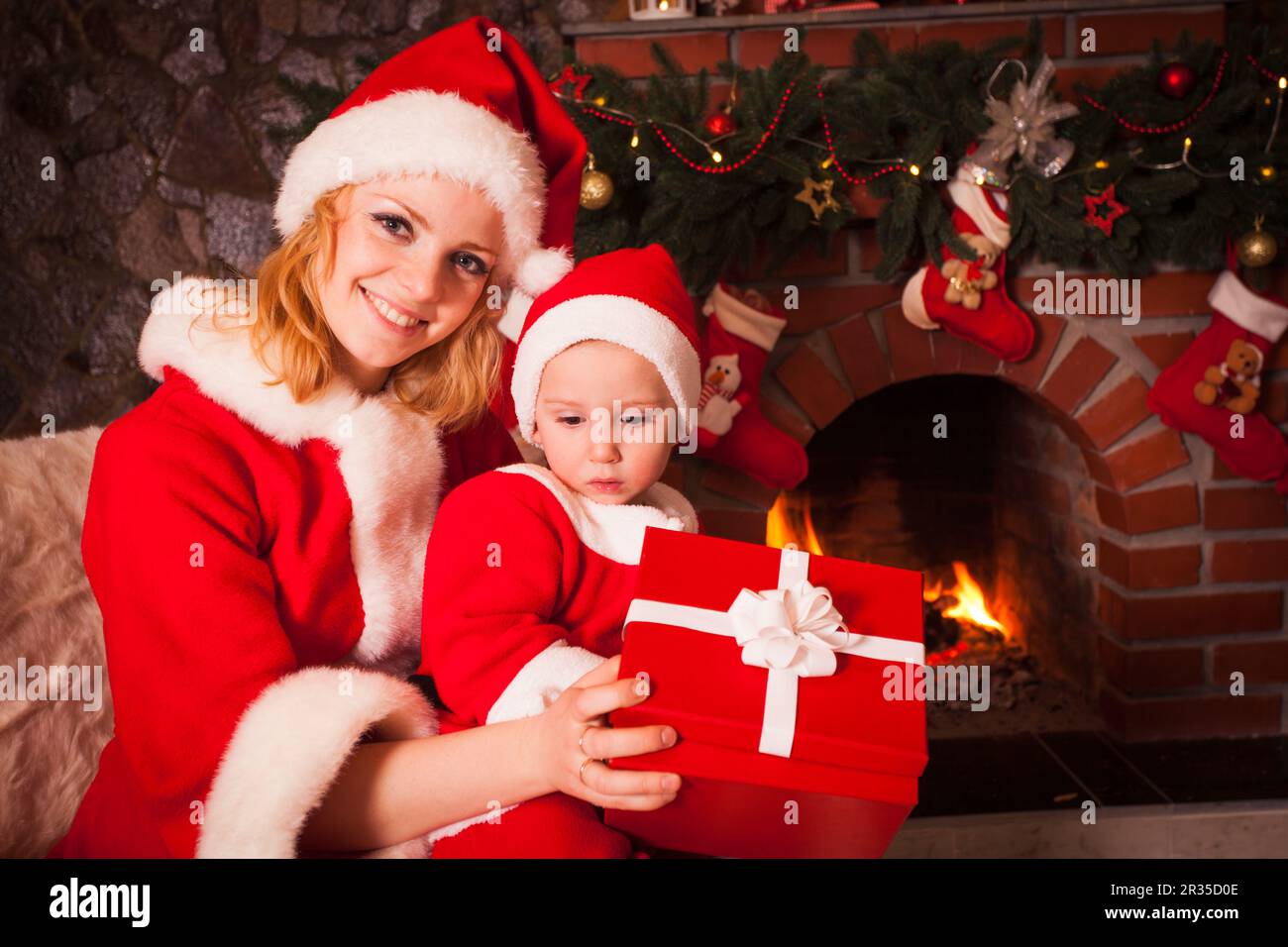 Mother and son near Christmas fireplace Stock Photo