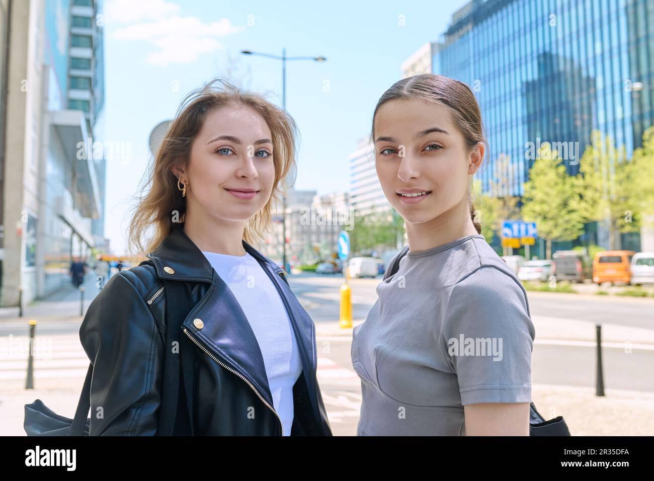 Two smiling female students looking at camera, urban modern background Stock Photo