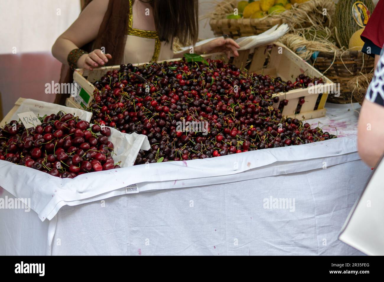 Selling cherries on a outside market. Basket full of cherries on street market. Stock Photo