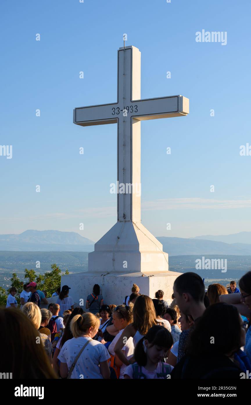 Pilgrims on an early morning around the white cross on the top of Mount