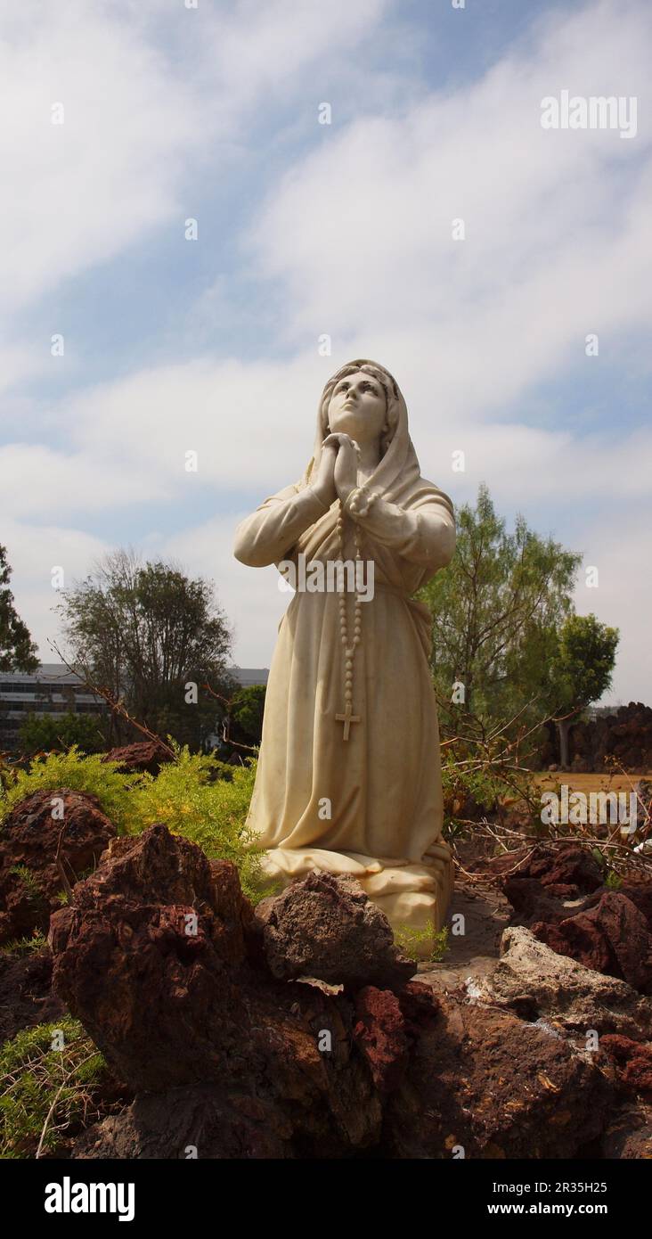 Statue of a girl praying with rosary Stock Photo Alamy